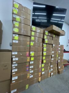 Packed boxes of disposable vape cartridges lineed up against a wall in a wholesale cannabis warehouse in the United States of America