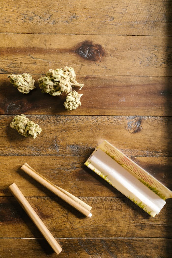 rolled paper and cannabis flower on wooden surface 8139707